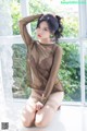 A woman sitting on a window sill in lingerie.