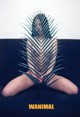 A naked woman sitting on a couch with a palm leaf in front of her.