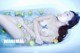 A naked woman laying in a bathtub filled with apples.