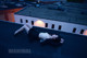 A woman laying on top of a roof next to a building.