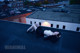 A woman laying on top of a roof next to a building.