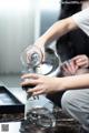 A woman pouring a glass of water into a glass.