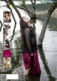 A woman standing in a body of water next to a tree.