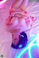 A woman laying on top of a bed covered in neon lights.