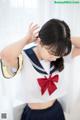 A woman in a sailor outfit with a red bow.