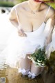 A woman in a white dress holding a bouquet of flowers.