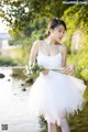 A woman in a white dress holding a bouquet of flowers.