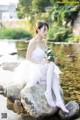 A woman sitting on a rock holding a bouquet of flowers.