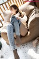 A woman sitting on a bean bag chair with her legs crossed.