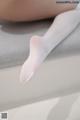 A close up of a woman's legs in white stockings.