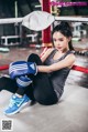 A woman sitting on the ground in a boxing ring.