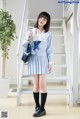 A woman in a blue and white school uniform posing for a picture.