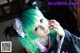 A woman with green hair wearing a kimono and a cat ears headband.