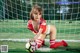 A woman in a red and white uniform holding a soccer ball.