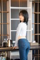 A woman standing in front of a counter with a coffee maker.