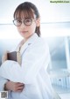 A woman in a lab coat holding a book.