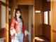 A woman in a red and blue hanbok standing in a doorway.