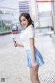 A woman holding a badminton racket on a city street.