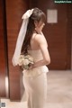 A woman in a wedding dress holding a bouquet of flowers.