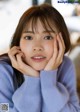 A woman in a blue sweater is posing for a picture.